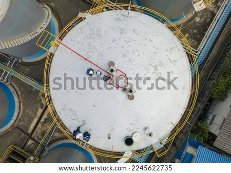 Male top view chemical industry tank storage white carbon steel worker are for inspection ultrasonic thickness roof plate dome top of storage tank.