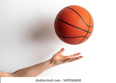 Male Tossing A Basketball In His Hand On A White Background
