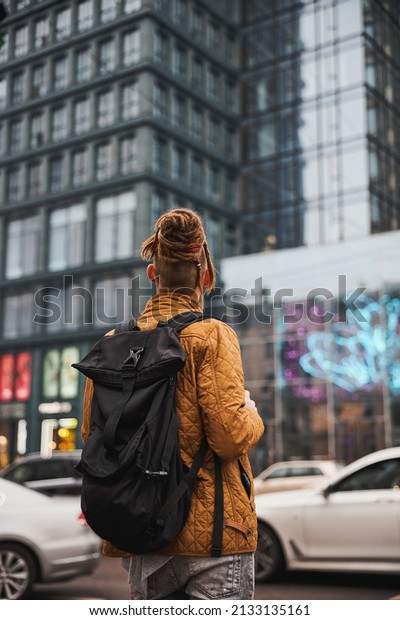 Male tourist\
with backpack walking in city\
centre