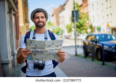 Male tourist with map in visiting European city in summer.Young man exlporing city - Shutterstock ID 2137389773