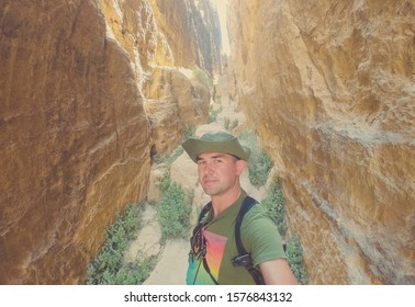 Male tourist at the narrow gorge tomb  in Litlle Petra, Jordan.