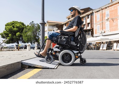 Male tourist on wheelchair crossing over the threshold ramp on the seaside promenade. Disability and accessible tourism concepts. - Powered by Shutterstock