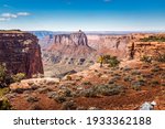 Male tourist walking along the rim at the Holeman Spring Canyon Overlook in the Island in the sky National Park, Utah