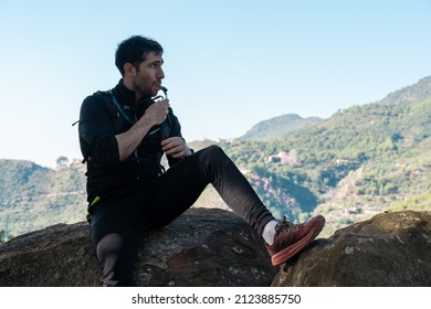 Male Trail Runner Resting And Drinking Water.