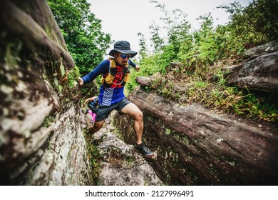 Male Trail Runner Running Through A Rock Channel Road