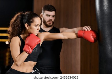 A male trainer guides a brunette sportswoman in active wear as they engage in a boxing session at the gym. - Powered by Shutterstock