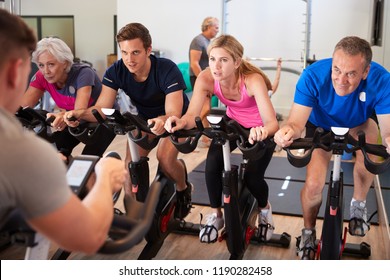 Male Trainer Taking Spin Class In Gym