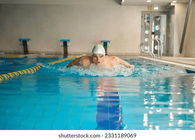 Male training back muscle group training in the pool - Shutterstock ID 2331189069