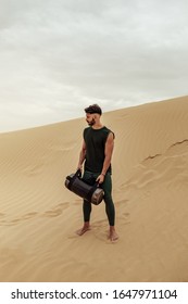 Male Training With Sandbag In The Desert