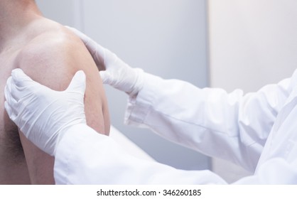 Male Traumatologist Orthopedics Surgeon Doctor Examining Middle Aged Man Patient To Determine Injury, Pain, Mobility And To Diagnose Medical Treatment In Shoulder, Arm, Elbow And Wrist. 