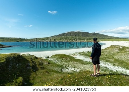 A male traveler admiring the scenery on Dog's Bay beach in Galway Ireland