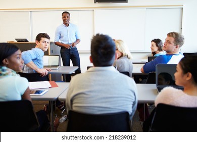 Male Tutor Teaching University Students In Classroom