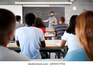 Male Tutor Teaching University Students In Classroom. Rear view from college attending at teacher in class. Professor explains the lesson on the blackboard. High quality photo - Powered by Shutterstock