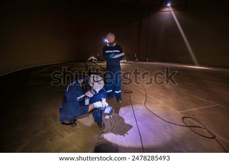 Male two worker inspection scan tank of rust thickness bottom plate area tank inside confined space