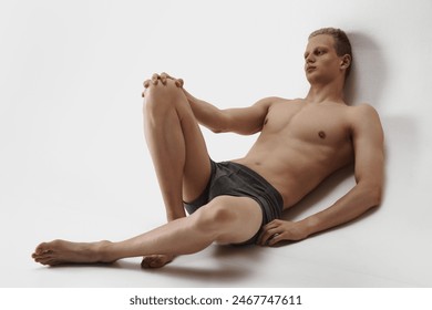 Male underwear line collection and. Handsome young man with muscular body posing in grey cotton boxers isolated on grey studio background. Concept of male beauty, body care, fitness, sport, health - Powered by Shutterstock