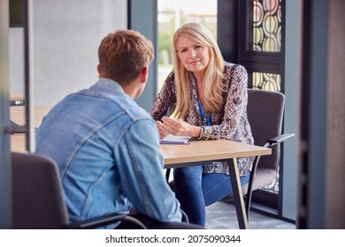 Male University Or College Student Having Individual Meeting With Tutor Or Counsellor