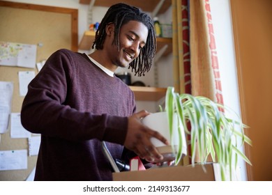 Male University Or College Student Moving Into Campus Room Unpacking  Plant