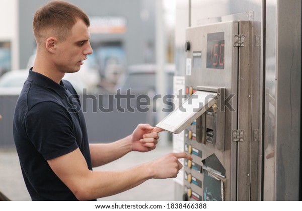 Male using self car washing. Man puts on the
button on the machine