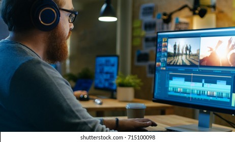 Male Videographer Edits and Cuts Footage and Sound on His Personal Computer, Puts on His Monitors/ Headphones. His Office is Modern and Creative Loft Studio. - Shutterstock ID 715100098