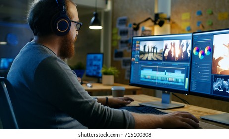 Male Videographer Edits and Cuts Footage and Sound on His Personal Computer, Puts on His Monitors/ Headphones. His Office is Modern and Creative Loft Studio.