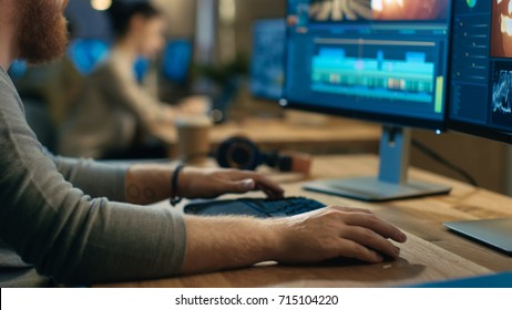 Male Videographer Edits and Cuts Footage and Sound on His Personal Computer with Two Displays. His Office is Modern and Creative Loft Studio. - Shutterstock ID 715104220