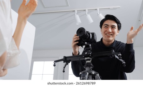 Male videographer filming a female model