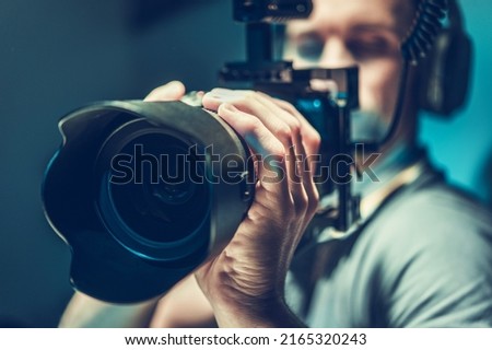 Male Videographer Focused and Concentrated on Recording the Footage with His Mirrorless Camera. Digital Videography Industry Theme.