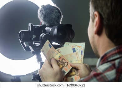 Male vlogger counting money from vlogging