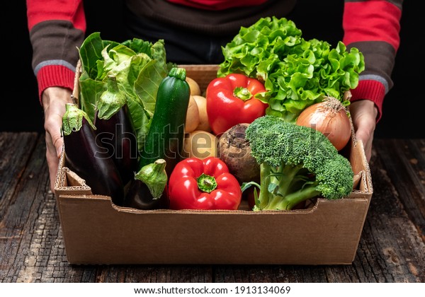 A male volunteer delivers food\
and vegetables to people in quarantine. Home insulation concept.\
Food delivery for people. Pandemic COVID-19\
concept