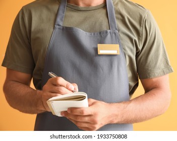 Male waiter with blank badge on color background - Shutterstock ID 1933750808