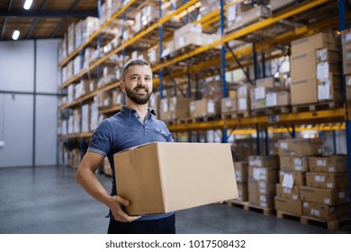 Male Warehouse Worker With A Large Box.