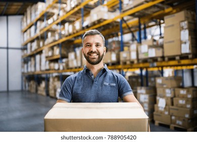 Male Warehouse Worker With A Large Box.