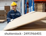 Male warehouse worker preparing cardboard boxes or corrugated paper sheet products for shipping to customer at warehouse store. Logistics, Distribution Center concept