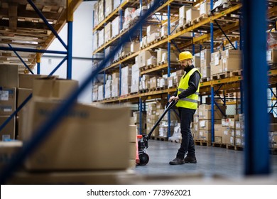 Male Warehouse Worker Pulling A Pallet Truck.