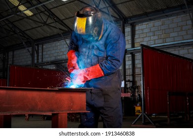 Male Welder At Work At A Metal Fabrication Workshop Welding A Plate Onto A Metal Section