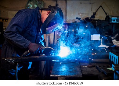 Male Welder At Work At A Metal Fabrication Workshop Welding A Plate Onto A Metal Section
