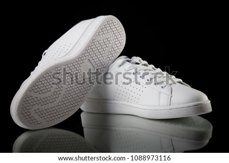 Male white sneaker on black background, isolated product, comfortable footwear.