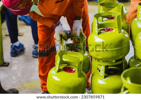 A male worker arranges 3 kg LPG gas cylinders