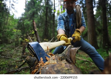 Male Worker With Ax Chopping A Tree In The Forest.