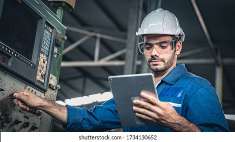 Male worker in blue jumpsuit and white hardhat operating the machine. - Shutterstock ID 1734130652