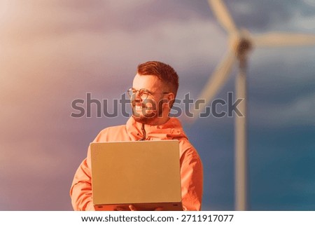 Male worker checking windpower project with laptop