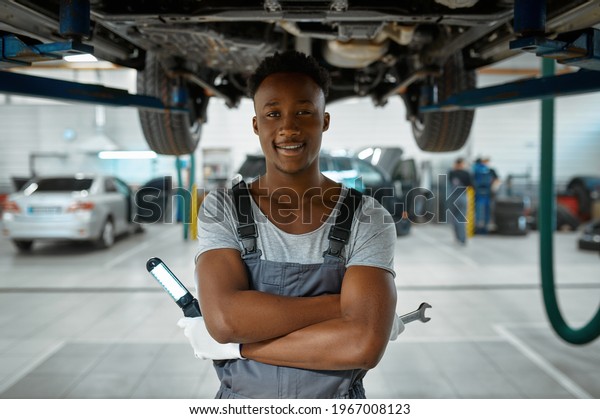 Male worker\
checks car suspension, auto\
service