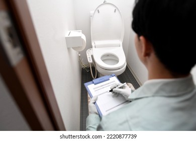 Male worker in front of the toilet - Shutterstock ID 2220877739
