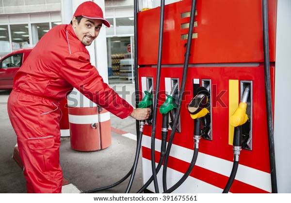 Male Worker At Gas Station Filling Up Customers\
Car With Petrol