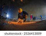 Male worker  grinding on steel plate with flash of sparks close up wear protective gloves oil inside confined spaces.