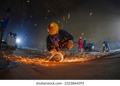 Male worker  grinding on steel plate with flash of sparks close up wear protective gloves oil inside confined spaces. - Powered by Shutterstock