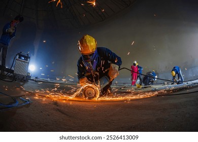 Male worker  grinding on steel plate with flash of sparks close up wear protective gloves oil inside confined spaces. - Powered by Shutterstock