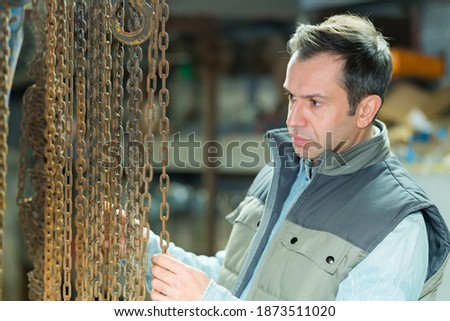 male worker hanging rusty chains