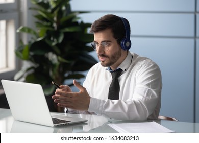 Male Worker In Headphones Makes Videocall Chatting With Partner, Consulting Client. Remote Discussion Solve Issues, New Technology, International Negotiators Interaction Through Virtual Apps Concept