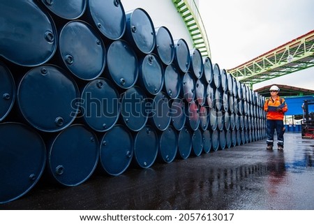 Male worker inspection record drum oil stock barrels blue horizontal or chemical for in the industry.